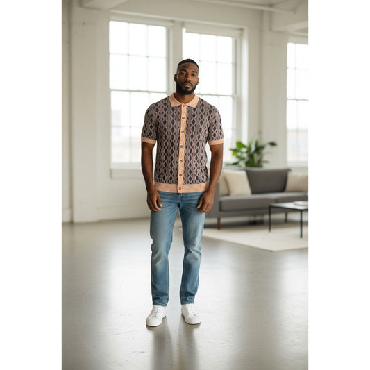 Man wearing a patterned shirt and jeans standing in a modern living room.
