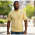 suit-yourself-menswear yellow textured knit polo shirt with a three-button placket worn by a man outdoors